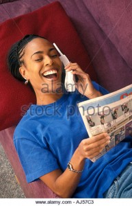 african-american-woman-laughing-talking-on-phone-reading-comics-aj57c3